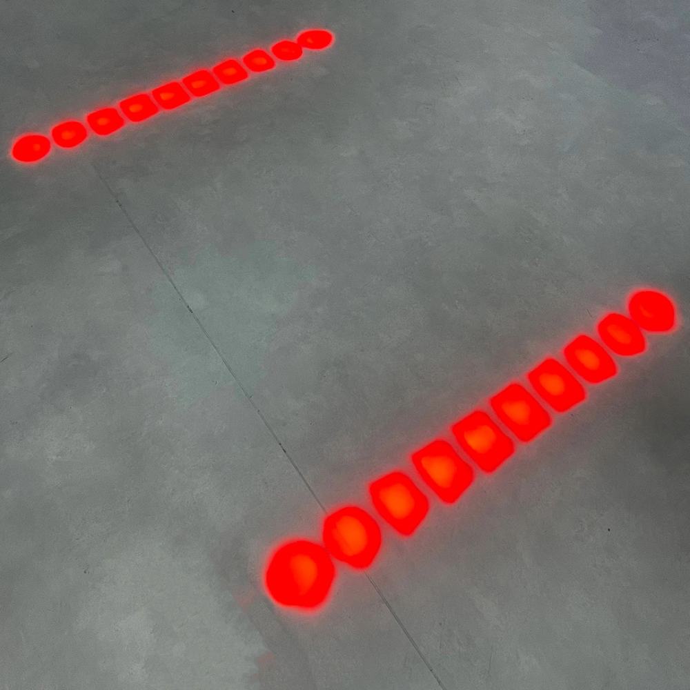 Two red lines of dots projected onto the floor